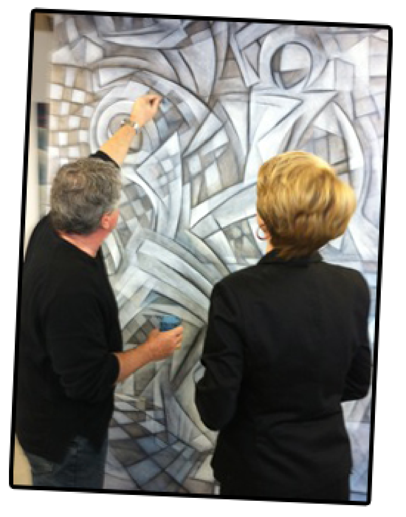 Leslie Mueller looks on as Paul Larson explains his process of painting.